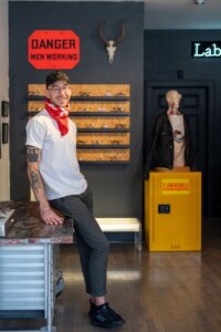 A man poses inside his glassware store