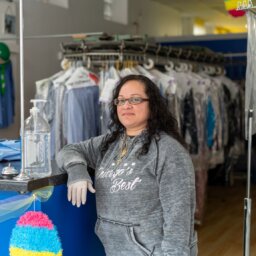 A dry cleaner worker poses in her store.