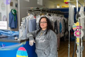 A dry cleaner worker poses in her store.