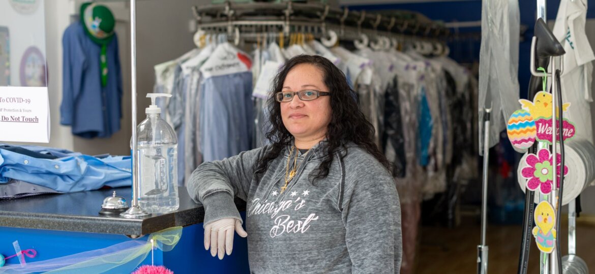 A dry cleaner worker poses in her store.