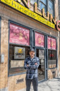 A man poses outside his restaurant